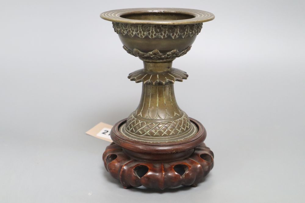 A 19th century Himalayan bronze urn, on carved stand, height 18cm